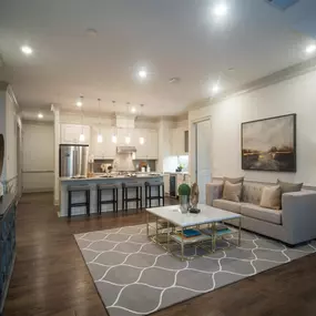 An open-concept living and dining area at Tindall Park at SouthPark Apartments with modern furnishings and warm lighting.