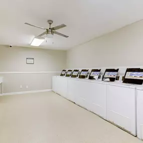 A clean and modern Laundry Care Center at Magnolia Terrace Apartments in Houston with high-efficiency machines.