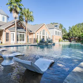 A sparkling swimming pool at Gramercy Park Apartments in Houston with a relaxing outdoor setting.