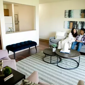 Open space living room with 2 people sitting on the couch