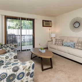a living room with a couch and a chair and a sliding glass door