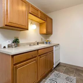A kitchen with wooden cabinets and a white fridge
