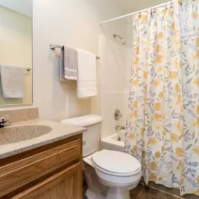 A bathroom with a toilet, sink, and shower curtain