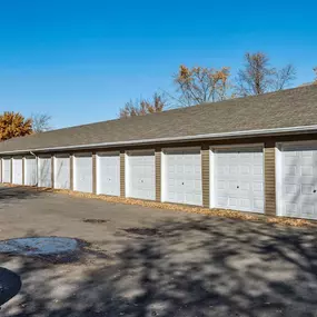 A long building with a grey roof and white garage doors