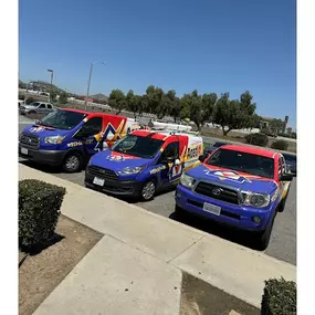 A fleet of Aced It! Cooling & Heating branded vehicles parked in Corona, CA, featuring bold and vibrant designs in red, blue, and yellow. The image highlights the company’s strong local presence and readiness to provide fast, reliable HVAC services to the community. Perfect for showcasing trust and professionalism.