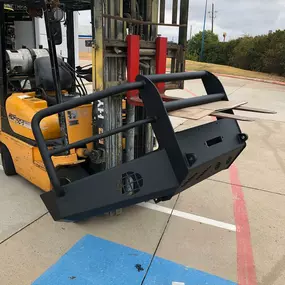 Line-X Trucks-N-Stuff in Plano TX offers commercial-grade spray-in coatings for forklifts, industrial parts, and heavy-duty equipment. Shown here is a forklift lifting a freshly coated bumper, ready for installation or delivery to a commercial client.