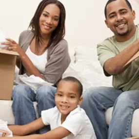 A family with homeowners insurance unpacking boxing inside a new house