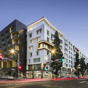 A modern building with a black and white facade stands on a street corner