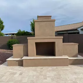 Enhance your backyard with a custom-built outdoor fireplace, complete with pavers and a seating area. This luxurious hardscaping addition adds warmth, ambiance, and functionality to any outdoor space.