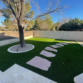 A stunning modern landscape design featuring concrete pavers, artificial turf, and decorative gravel. This low-maintenance outdoor space is perfect for contemporary homes looking for aesthetic and functional landscaping solutions.