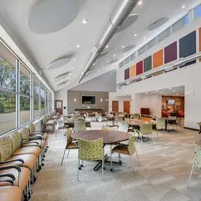 A large room with tables and chairs and a fire extinguisher on the wall