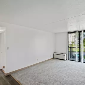 A room with white walls and a window with blinds