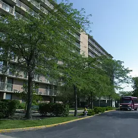 A street view of a residential area with apartment buildings and parked cars