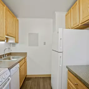 A kitchen with white appliances and wooden cabinets