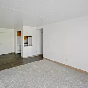 A large empty room with a carpeted floor and white walls