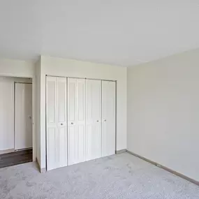 A room with white cupboards and a grey carpet