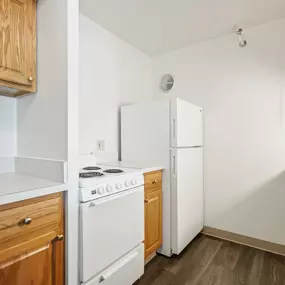 A kitchen with a white stove and white refrigerator