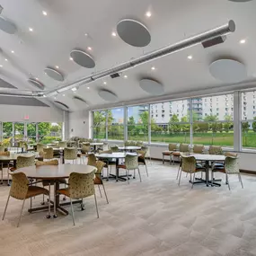 A room with tables and chairs and a lot of windows