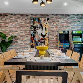 This vibrant dining space blends urban charm with artistic flair, thanks to the bold brick-inspired wallcoverings in Arizona by The Wallpaper Co. The textured backdrop adds warmth and personality, perfectly framing the colourful portrait and retro arcade corner. It’s a lively, inviting space where modern design meets playful nostalgia, and we’re here for it!