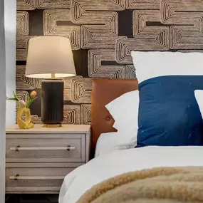 This chic and cozy bedroom gets an instant upgrade with bold, geometric wallpaper from The Wallpaper Co., a trusted name for premium wallcoverings in Phoenix. The textured design adds depth and movement, beautifully complementing the warm leather headboard and modern decor. It’s a subtle yet powerful way to elevate your space with personality and style.