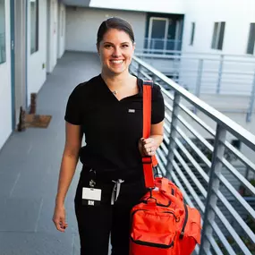 Smiling mobile IV nurse arriving for an in-home IV therapy session in Los Angeles.