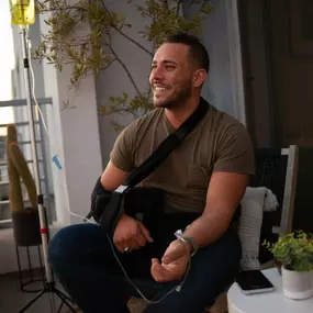 Man receiving mobile IV therapy on a Los Angeles balcony for hydration and recovery.