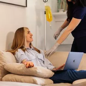 Smiling woman receiving mobile IV therapy at home in Los Angeles.