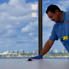 TamCare Services employee meticulously cleaning and sanitizing an office desk, ensuring a spotless and hygienic workspace. Professional janitorial services for office cleanliness and health.