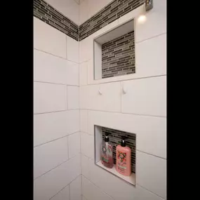 ZimmTown Construction’s bathroom remodel showcases a beautifully tiled shower with modern fixtures, offering a sleek and refreshing design. Thoughtful details, from stylish tilework to efficient storage, create a functional and inviting space for everyday comfort.