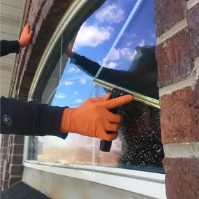 Window being cleaned by hand with a squeegee.