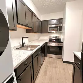 Kitchen with black cabinets and white countertops and a stainless steel appliances