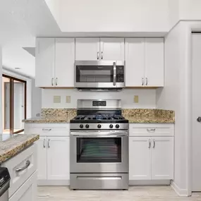 A kitchen with a granite countertop and stainless steel appliances