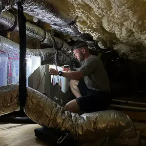 Ebens Air Conditioning Technician in the attic working on the Air Handler.