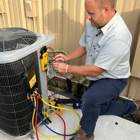 Ebens Air Conditioning Technician outside working on Condenser.