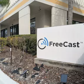 An exterior view of FreeCast, Inc.'s corporate headquarters, showcasing a prominently displayed branded sign in front of a modern office building.