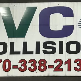 JVC Collision sign in Kingston, PA, featuring bold red, green, and purple lettering, a spray gun graphic, and the phone number 570-338-2136