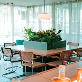 Une grande table carrée design et fonctionnelle, mise en valeur par une touche végétale en son centre. Un espace partagé, calme et inspirant, parfait pour travailler en solo ou en petit groupe dans l’ambiance détendue du Greet Hôtel Montpellier à Mauguio.