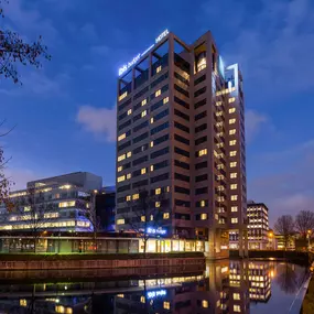 Ibis Budget Amsterdam South shines at night with its illuminated facade, creating a welcoming atmosphere. The lighting highlights the hotel’s inviting exterior, offering an affordable and comfortable stay for guests.