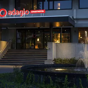 The front of Adagio Amsterdam City South is beautifully illuminated at night, showcasing its modern architecture, prominent logo, and an elegant fountain. The stunning night view reflects the property’s welcoming atmosphere and commitment to providing a stylish and comfortable experience for long-stay guests.