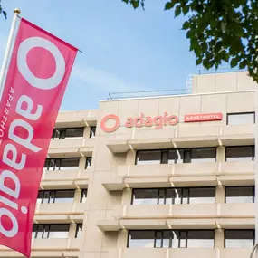 The Adagio Amsterdam City South building showcases a modern design, featuring the prominently displayed Adagio logo and a striking red flag adorned with the logo. This stylish exterior reflects the property’s welcoming ambiance and its focus on long-stay comfort and convenience.