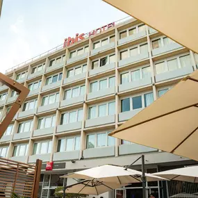 Façade de l’hôtel ibis Alès Centre-Ville vue depuis la terrasse ensoleillée.