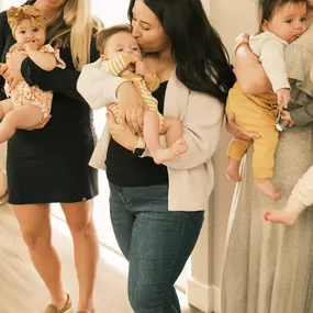 A new mom holds her baby close and kisses their forehead