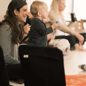 Moms and their babies sit at a table laughing and learning