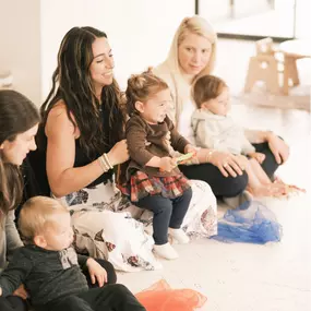 Three moms lined up with their babies in their laps during a class