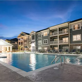 A large swimming pool is surrounded by apartment buildings