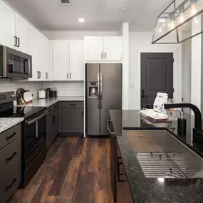 Kitchen with two-tone light and dark cabinets and wood-style flooring at Camden West Nashville apartments in Nashville, TN