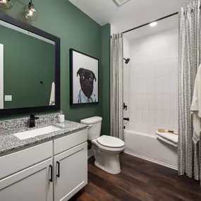 Bathroom with granite countertop and tile surrounded bathtub at Camden West Nashville apartments in Nashville, TN