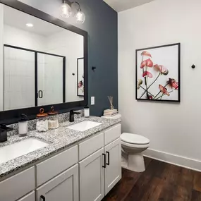 Bathroom with double sink vanity and glass-enclosed shower at Camden West Nashville apartments in Nashville, TN