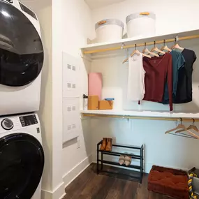 Spacious closet with built-in wood shelves and stackable washer and dryer at Camden West Nashville apartments in Nashville, TN