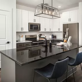 Kitchen with light and dark cabinets and countertops and modern island pendant fixture at Camden West Nashville apartments in Nashville, TN